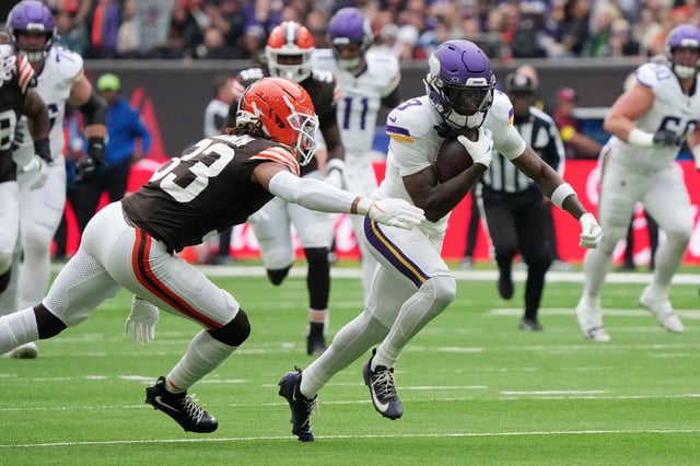 Oct 5, 2025; Tottenham, United Kingdom; Minnesota Vikings wide receiver Jordan Addison (3) runs with the ball against Cleveland Browns safety Ronnie Hickman Jr. (33) during the third quarter of an NFL International Series game at Tottenham Hotspur Stadium. Mandatory Credit: Kirby Lee-Imagn Images