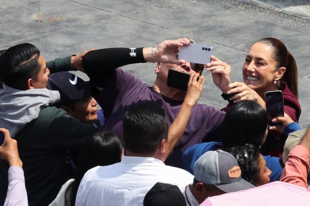 Mexico's President Claudia Sheinbaum poses for a selfie with a supporter, as she arrives to deliver a speech marking her first year in office, reporting on government actions included in her first State of the Union address, to supporters and government officials at Zocalo Square, in Mexico City, Mexico, October 5, 2025. REUTERS/Henry Romero