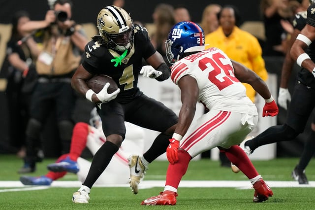 New Orleans Saints cornerback Kool-Aid McKinstry (4) runs after intercepting a ball as New York Giants running back Devin Singletary (26) defends in the second half of an NFL football game, Sunday, Oct. 5, 2025, in New Orleans. (AP Photo/Gerald Herbert)