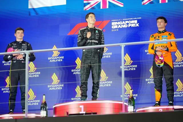 El británico George Russell de Mercedes, ganador del Gran Premio de Singapur, flanqueado por el neerlandés Max Verstappen de Red Bull, segundo, y el británico Lando Norris de McLaren el domingo 5 de octubre del 2025. (AP Foto/Vincent Thian)