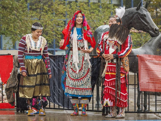  Dancers Honey Bull, left, Isabella Corderre and Vanessa Hunter wait in the rain at the Sisters in Spirit vigil, which honours missing and murdered Indigenous women and girls and shows support for their loved ones, in Calgary on Saturday, Oct. 4, 2025.