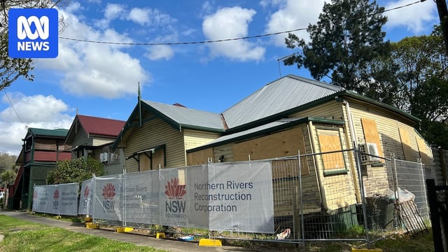 weatherboard home off its stumps, with security fence around it