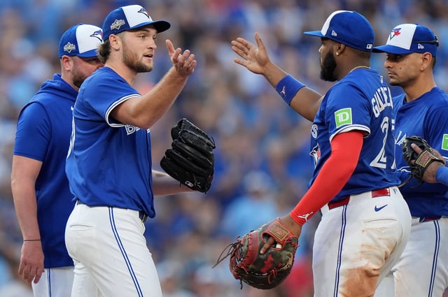 El lanzador novato de los Azulejos de Toronto, el estadounidense Trey Yesavage, al frente izquierda, celebra con su compañero de equipo, el dominicano Vladimir Guerrero Jr., al frente derecha, después de ser retirado del montículo por el mánager  John Schneider, detrás izquierda, durante la sexta entrada del Juego 2 de la Serie Divisional de la Liga Americana de béisbol contra los Yankees de Nueva York en Toronto, el domingo 5 de octubre de 2025. (Frank Gunn/The Canadian Press vía AP)