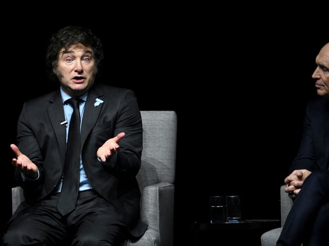 Argentine President Javier Milei (L) speaks next to National Deputy Jose Luis Espert during the presentation of his new book "Capitalism, Socialism, and the Neoclassical Trap" at the Luna Park stadium in Buenos Aires on May 22, 2024. (Photo by LUIS ROBAYO / AFP)
