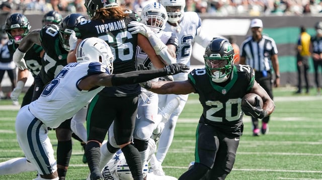 New York Jets running back Breece Hall (20) carries the ball as he works around Dallas Cowboys safety Donovan Wilson (6) during the first half at MetLife Stadium. Mandatory Credit: Robert Deutsch-Imagn Images