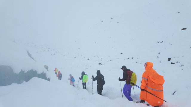 Ein Screenshot aus einem Video zeigt Wanderer, die ihren Lagerplatz verlassen, als ungewöhnlich starker Schneefall und Regen den Himalaya in der Region Tibet in China heimsuchten.