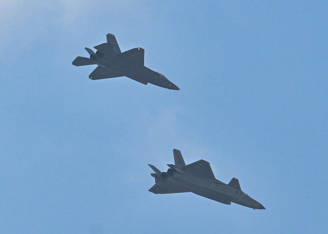 A J-20 fighter jet, bottom, and a J-35A fighter jet fly in formation during a military parade at Tiananmen Square in Beijing, China, on September 3, 2025.