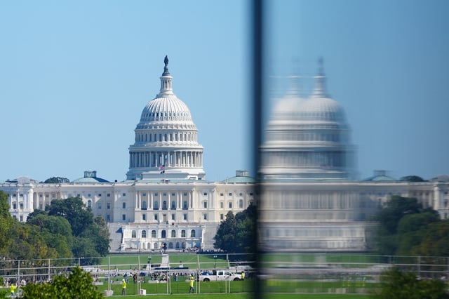 People walk near the U.S. Capitol Building during the fifth day of a partial government shutdown in Washington, D.C., U.S., October 5, 2025. REUTERS/Aaron Schwartz