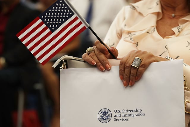 A person holds an American flag as they participate in a ceremony to become an American citizen during a U.S. Citizenship & Immigration Services naturalization ceremony at the Miami Field Office on August 17, 2018 in Miami, Florida. The ceremony included 141 citizenship candidates that originated from the following 33 countries: Argentina, Brazil, Bulgaria, Cameroon, Chile, Colombia, Costa Rica, Cuba, Dominican Republic, Ecuador, El Salvador,  France, Grenada, Guatemala, Haiti, Honduras, Hungry, Israel, Italy, Jamaica, Jordan, Lithuania, Mexico, Nicaragua, Nigeria, Phillippines, Slovakia, Spain, Ukraine, United Kingdom, Uruguay, Uzbekistan and Venezuela.