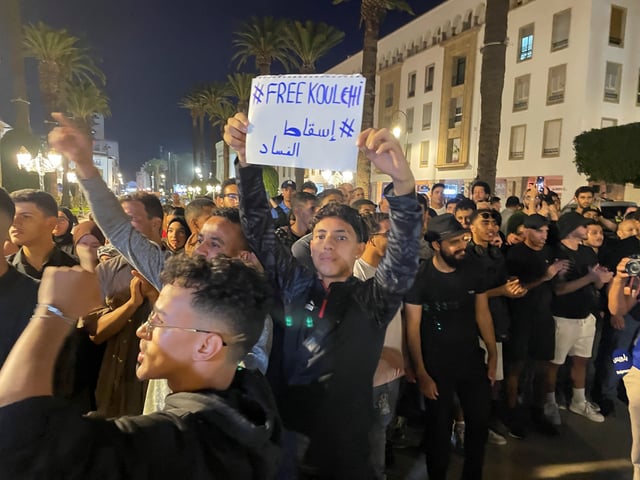 A man holds a sign which reads "overthrowing corruption", as demonstrators attend a protest for social justice, near the parliament building, in Rabat, Morocco, October 3, 2025. REUTERS/Ahmed El Jechtimi