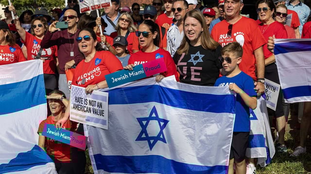 Demonstrators hold Israeli flags and signs that read. "Jewish Miami Proud" and "Hate is not an American value" during a solidarity "Run for Their Lives" walk to raise awareness for the hostages still held in Gaza at Aventura Circle on June 8, 2025, in Aventura, Fla. Photo: D.A. Varela/Miami Herald/Tribune News Service via Getty Images