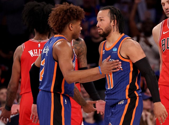 NEW YORK, NEW YORK - APRIL 14: Jalen Brunson #11 of the New York Knicks is congratulated by teammate Miles McBride #2 after Brunson scored his 31st point and tied the franchise record with most 30 point games in a single season during the second half at Madison Square Garden on April 14, 2024 in New York City. The New York Knicks defeated the Chicago Bulls 120-119 in OT. NOTE TO USER: User expressly acknowledges and agrees that, by downloading and or using this photograph, User is consenting to the terms and conditions of the Getty Images License Agreement. (Photo by Elsa/Getty Images)