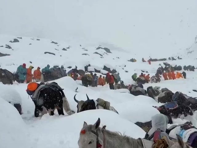Auf diesem Foto steigen Dorfbewohner mit ihren Ochsen und Pferden den Berg hinauf, während sie versuchen, Hunderte von Wanderern zu erreichen, die durch den starken Schneefall in den Touristenlagern am Hang des Mount Everest in Tibet eingeschlossen sind.