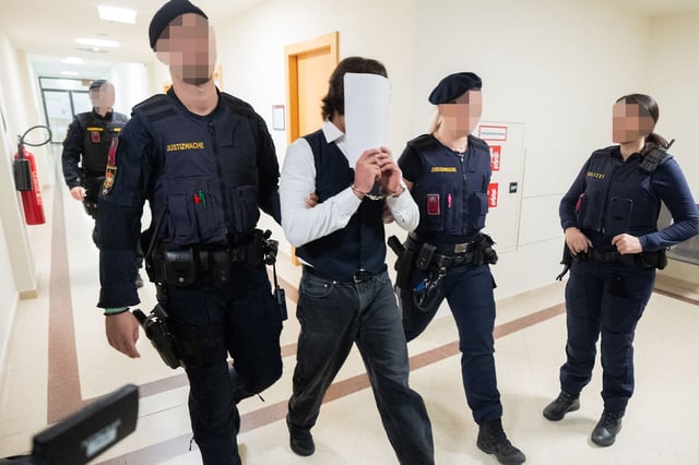 Ein weiterer Angeklagter wird in einen Gerichtssaal geführt