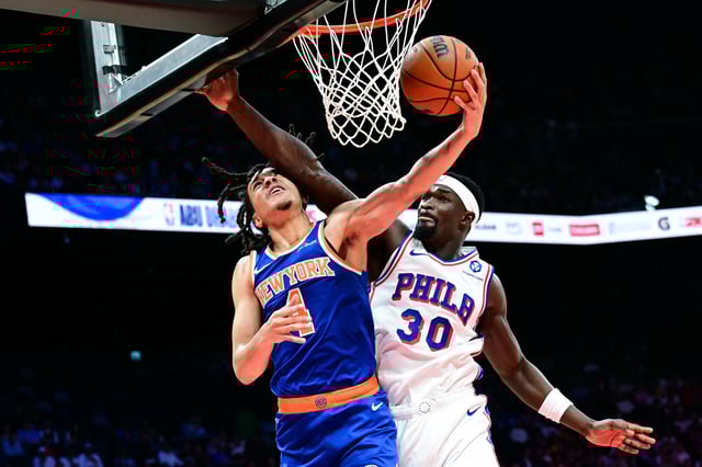 New York Knicks' #04 Pacome Dadiet goes to the basket as Philadelphia 76ers' #30 Adem Bona defends during the NBA basketball game between the New York Knicks and the Philadelphia 76ers at the Etihad Arena in Abu Dhabi on October 2, 2025. (Photo by Giuseppe CACACE / AFP) (Photo by GIUSEPPE CACACE/AFP via Getty Images)