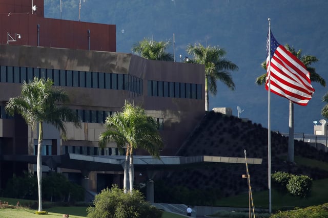 A man walks next to a U.S. flag at the U.S. Embassy in Caracas, Venezuela January 24, 2019. Picture taken January 24, 2019. REUTERS/Carlos Garcia Rawlins