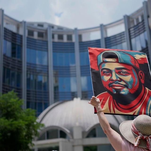 FILE - Katheryn Millwee holds a portrait of Kilmar Abrego Garcia outside the federal courthouse on June 25, 2025, in Nashville, Tenn. (AP Photo/George Walker IV, File)