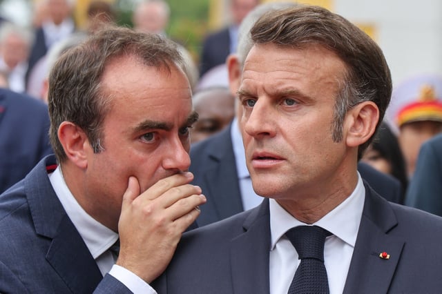 El presidente de Francia, Emmanuel Macron (der.), escucha al ministro de las Fuerzas Armadas, Sébastien Lecornu, en Hanói el 26 de mayo de 2025. (Foto de Ludovic MARIN / AFP).