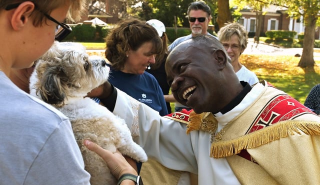 Rev. Patrick Kizza, administrator at St. Patrick Catholic Church in Lake Forest, engages with attendees and pets on Oct. 4, 2025.