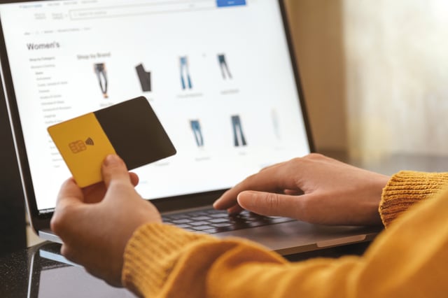 Female hands in yellow sweater do shopping online using laptop and credit card. Digital currency, CBDC, Technology, AI, chat bot, neural network, technology, business concept