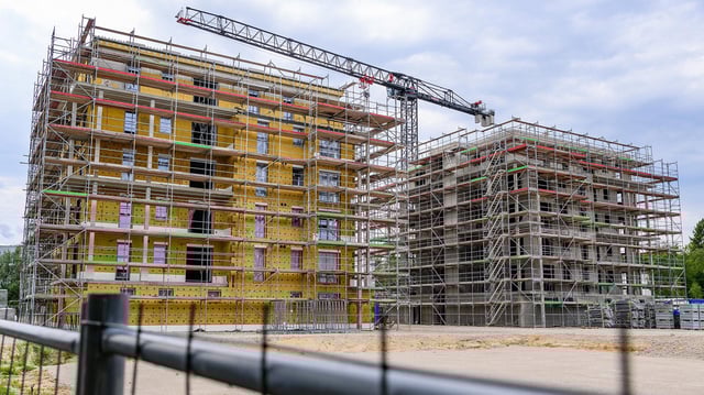 Eine Baustelle auf der zwei Häuser mit mehreren Wohneinheiten entsteht.