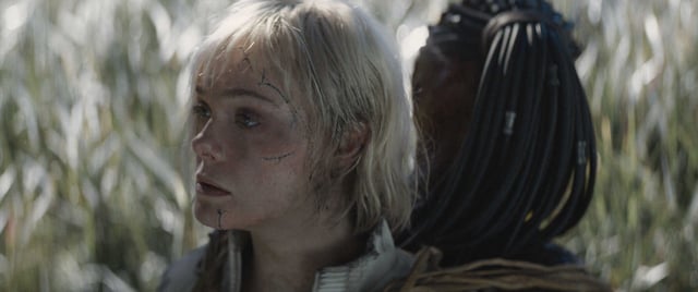 (L-R) Elle Fanning as Thia and Dimitrius Schuster-Koloamatangi as Dek in 20th Century Studios' PREDATOR: BADLANDS film. Photo courtesy of 20th Century Studios. © 2025 20th Century Studios. All Rights Reserved.
