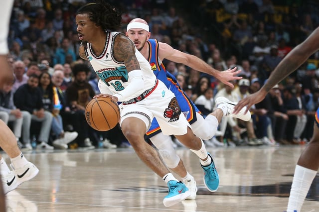 Apr 24, 2025; Memphis, Tennessee, USA; Memphis Grizzlies guard Ja Morant (12) drives to the basket as Oklahoma City Thunder guard Alex Caruso (9) defends during the second quarter during game three for the first round of the 2024 NBA Playoffs at FedExForum. Mandatory Credit: Petre Thomas-Imagn Images/File Photo