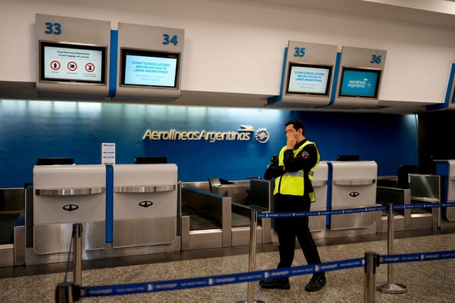 Un oficial de seguridad se encuentra en el mostrador vacío de Aerolíneas Argentinas cuyos trabajadores están en huelga por salarios más altos en el aeropuerto Jorge Newbery en Buenos Aires, Argentina, el viernes 13 de septiembre de 2024. (AP Foto/Natacha Pisarenko)