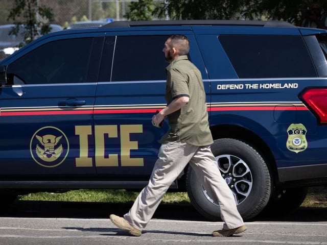 A man walks past an ICE vehicle in Chicago on Sept. 8, 2025. 