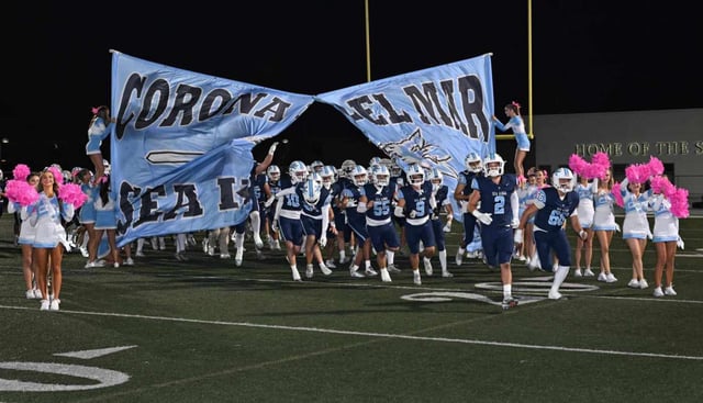 The Corona del Mar football team take the field at the start of a Friday night football game against San Juan Hills at Newport Harbor High. (Photo by Steven Georges, Contributing Photographer)