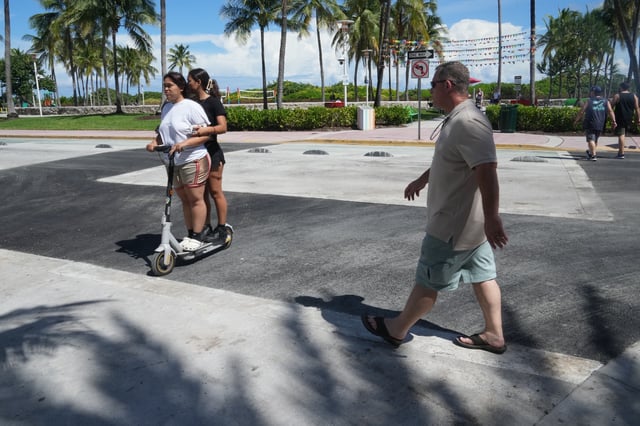 Pedestrians walk over a crosswalk on Miami Beach's iconic Ocean Drive that used to be rainbow-colored celebrating the history and contributions of the LGBTQ+ community, Monday, Oct. 6, 2025. (AP Photo/Marta Lavandier)