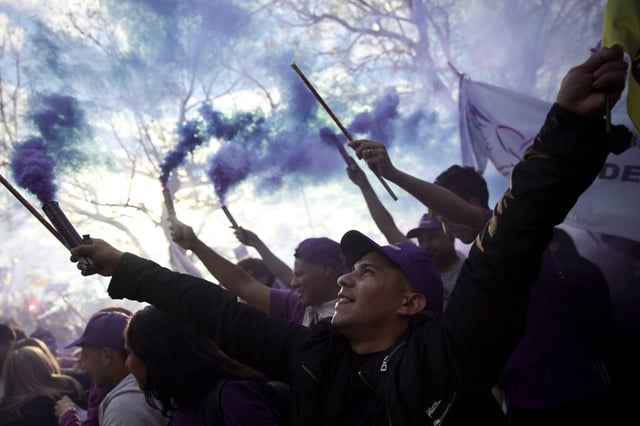 Supporters of Argentina's embattled President Javier Milei light smoke flares before his rock concert to launch his latest book on his auto-proclaimed economic 'miracle'