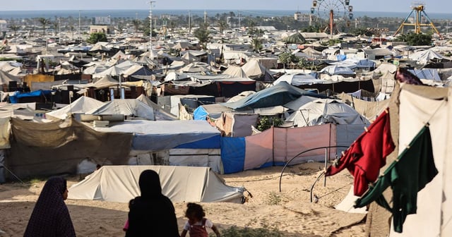 Women and children sit at a camp for displaced Palestinians in Khan Younis, southern Gaza, on September 29. AFP