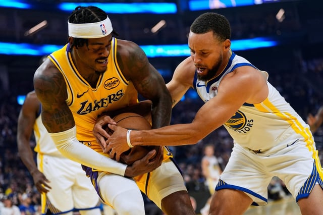 Lakers forward Jarred Vanderbilt, left, and Golden State Warriors guard Steph Curry compete for possession of the ball during the first half of Sunday’s preseason game in San Francisco. (AP Photo/Godofredo A. Vásquez)