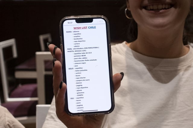Una argentina muestra su lista de compras en Santiago.