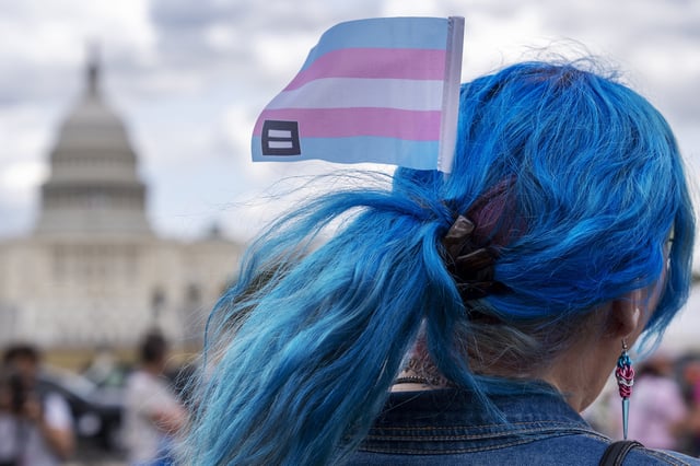 FILE - With the Capitol in the background, Kali wears a trans equality flag in her hair while attending a rally for the Trans Day of Visibility on the National Mall, March 31, 2025, in Washington. (AP Photo/Jacquelyn Martin, File)