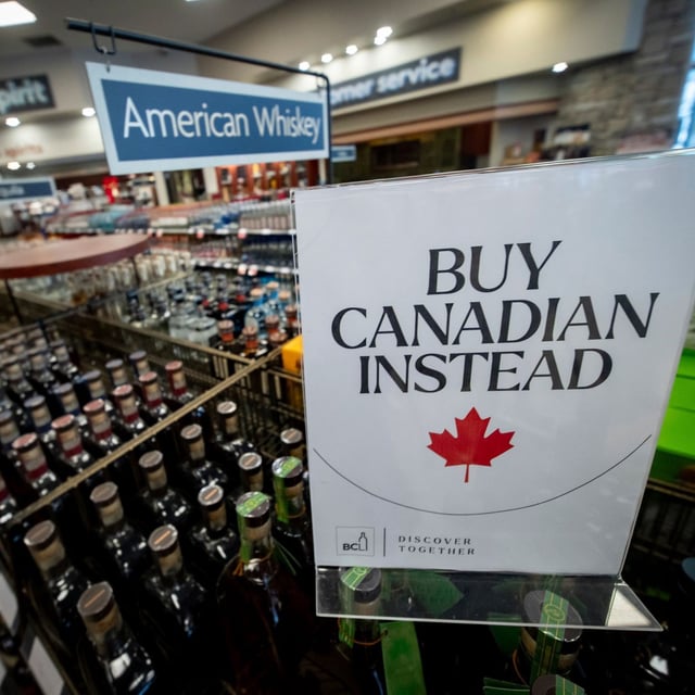 FILE - A sign is placed in front of the American whiskey section at a B.C. liquor store after top-selling American-made products have been removed from shelves in Vancouver, B.C., Sunday, Feb. 2, 2025. (Ethan Cairns/The Canadian Press via AP)