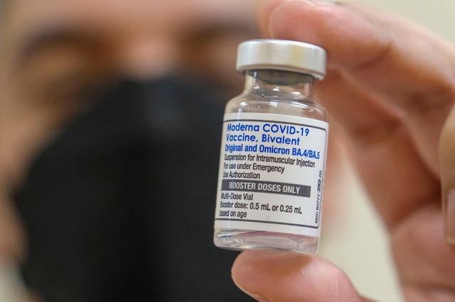 Un farmacéutico sostiene un vial de la vacuna Moderna contra la COVID-19, Bivalent, en la clínica médica AltaMed de Los Ángeles, California. (Foto de RINGO CHIU / AFP / ARCHIVO)