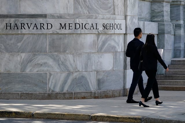 Pedestrians walk towards the Harvard Medical School, Aug. 18, 2022, in Boston.  Jeremy Pauley has pleaded guilty to federal charges stemming from the theft and sale of human body parts taken from Harvard Medical School and an Arkansas mortuary, Friday, Sept. 8, 2023.