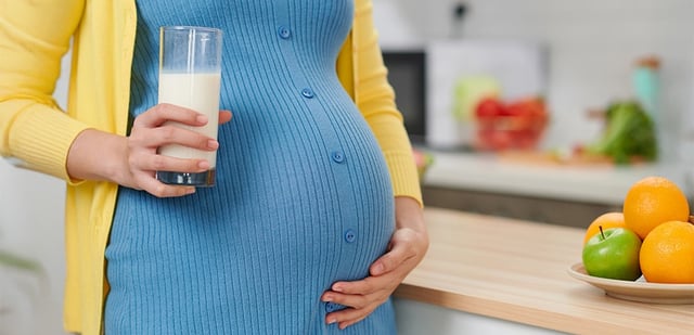 Pregnant woman with a probiotic drink