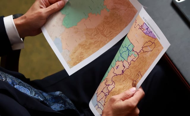 A representative looks at proposed maps during discussions of SB1012 Congressional Boundaries Designation in the House chamber at the Capitol in Salt Lake City on Monday, Oct. 6, 2025.