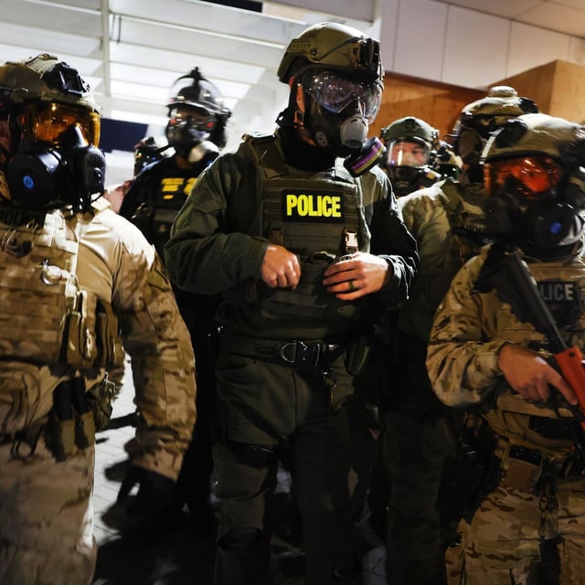 PORTLAND, OREGON - OCTOBER 05: Federal agents, including members of the Department of Homeland Security, Border Patrol, and the police, attempt to keep protesters back outside a downtown U.S. Immigration and Customs Enforcement (ICE) facility on October 05, 2025 in Portland, Oregon. The facility has become a focal point of nightly protests against the Trump administration and President Trump's announcement that he will be sending National Guard troops into Portland.   (Photo by Spencer Platt/Getty Images)