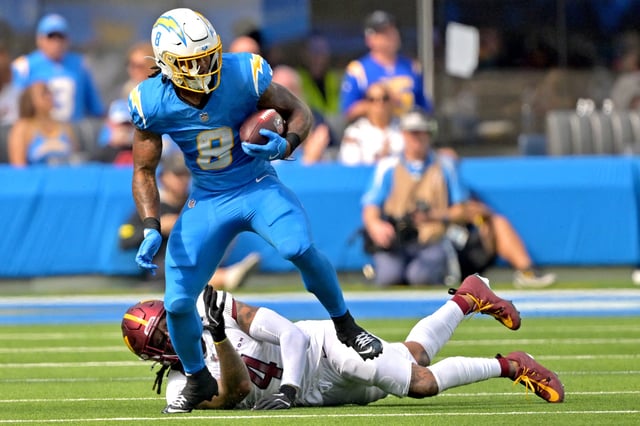 Oct 5, 2025; Inglewood, California, USA; Los Angeles Chargers running back Omarion Hampton (8) breaks away from Washington Commanders linebacker Frankie Luvu (4) as he carries the ball at SoFi Stadium. Mandatory Credit: Jayne Kamin-Oncea-Imagn Images