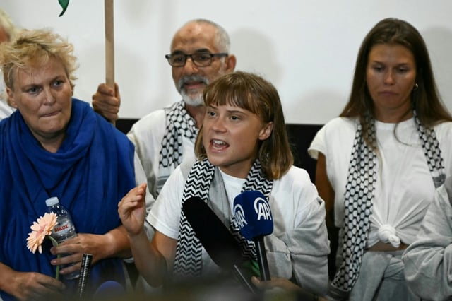 La militante suédoise pour le climat Greta Thunberg (au centre) prononce un discours à son arrivée à l'aéroport d'Athènes le 6 octobre 2025, aux côtés de militants qui naviguaient à bord de la flottille pour Gaza avant d'être arrêtés et expulsés par les forces israéliennes.