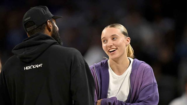 Oct 6, 2025; Fort Worth, Texas, USA; Dallas Mavericks guard Kyrie Irving (left) talks with Dallas Wings guard Paige Bueckers (right) during the second half of the game between the Mavericks and the Oklahoma City Thunder at Dickie's Arena. Mandatory Credit: Jerome Miron-Imagn Images