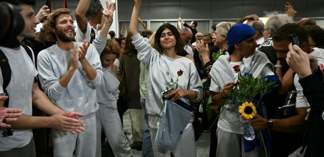 L'eurodéputée franco-palestinienne LFI (gauche radicale) Rima Hassan fait le signe de paix à son arrivée à l'aéroport d'Athènes le 6 octobre 2025, aux côtés des militants qui naviguaient à bord de la flottille pour Gaza avant d'être arrêtés et expulsés par les forces israéliennes.