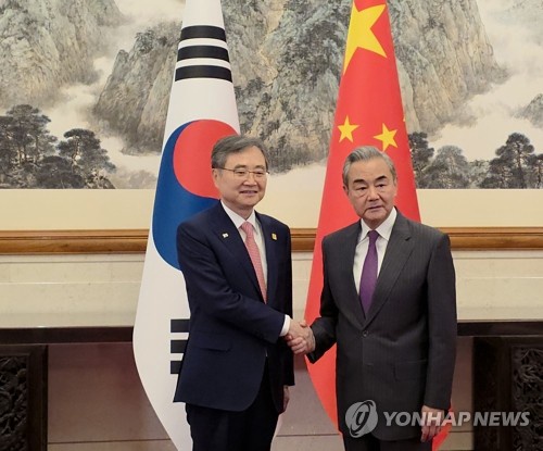Foreign Minister Cho Hyun (L) shakes hands with his Chinese counterpart, Wang Yi, as they meet for talks in Beijing on Sept. 17, 2025, in this file pool photo. (PHOTO NOT FOR SALE) (Yonhap)