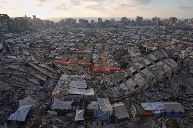 FILE.- A tent camp for displaced Palestinians stretches among the ruins of buildings destroyed by Israeli bombardments in west Gaza City, Saturday, June 21, 2025. (AP Photo/Jehad Alshrafi, File)