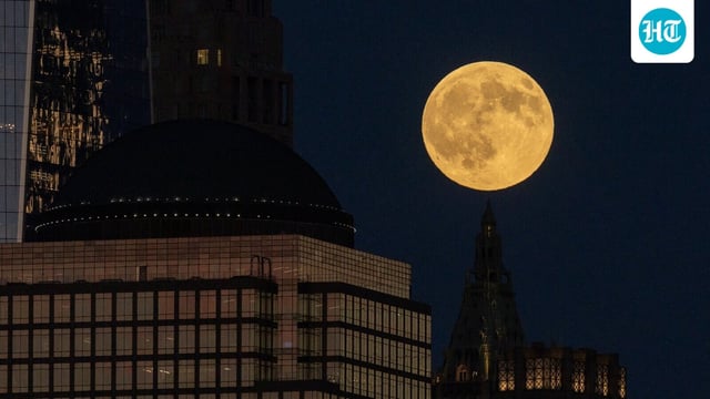 The first supermoon of the year, known as the Harvest Moon, rises above lower Manhattan.