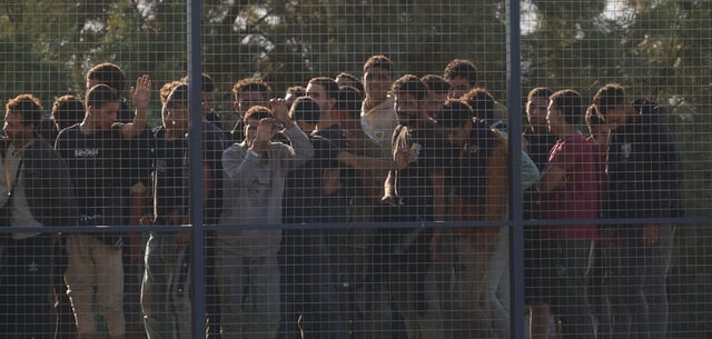 Migranten, die südlich von Kreta gerettet wurden, warten nach ihrer Ankunft im Hafen von Lavrio auf ihre Registrierung